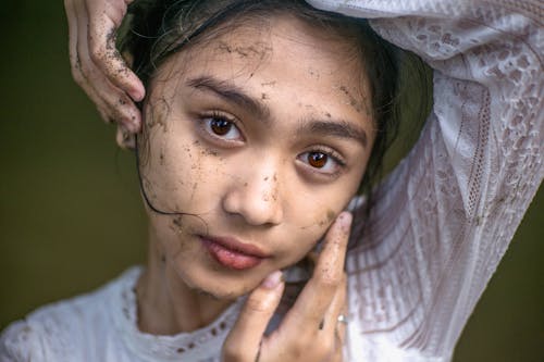 Girl in White Shirt With Hand on Face