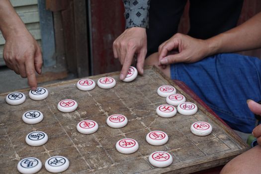 People engaged in an outdoor Xiangqi game in Ha Giang, Vietnam, showcasing traditional strategy.