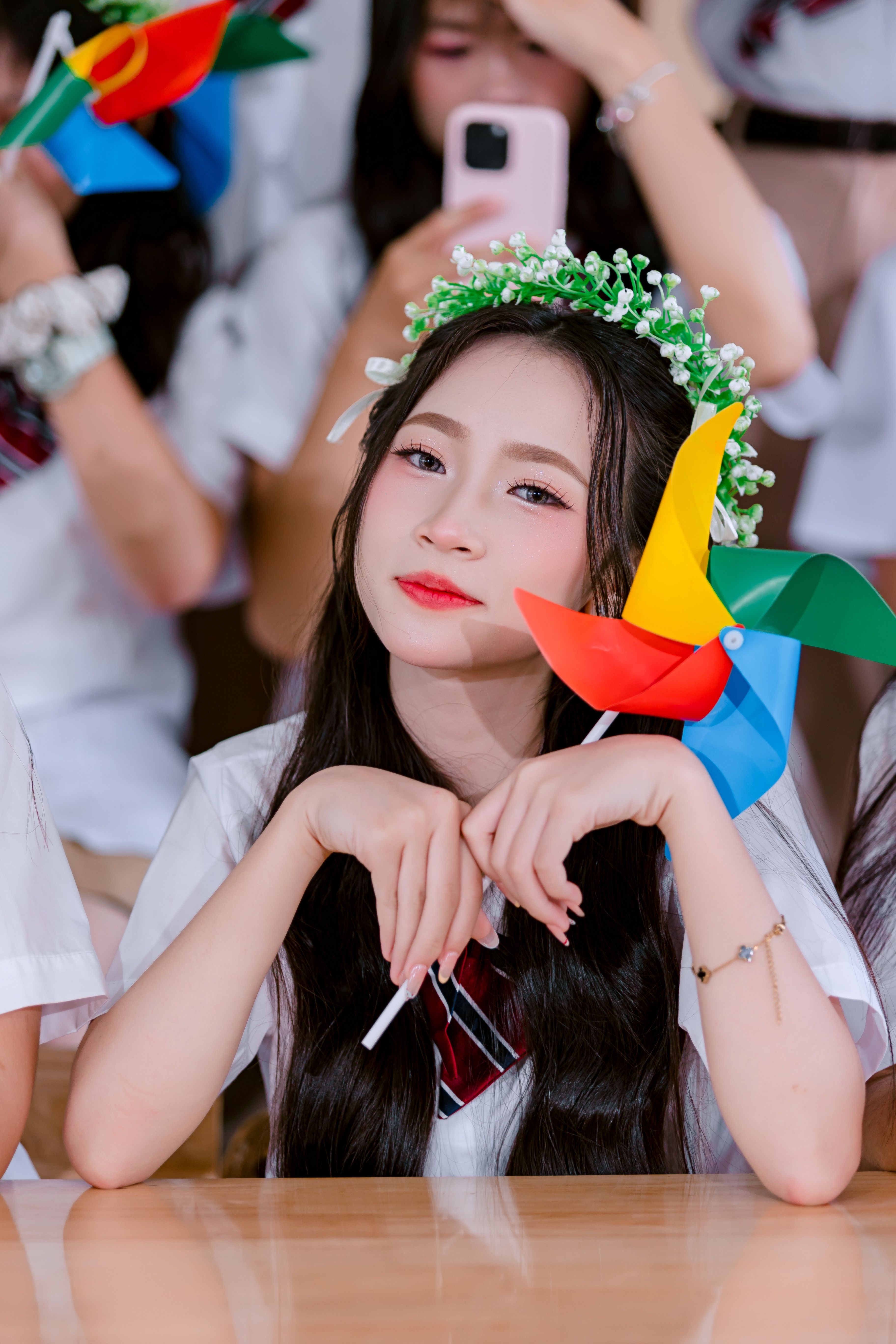 Young woman with a pinwheel at a lively school event, capturing joyful school spirit.