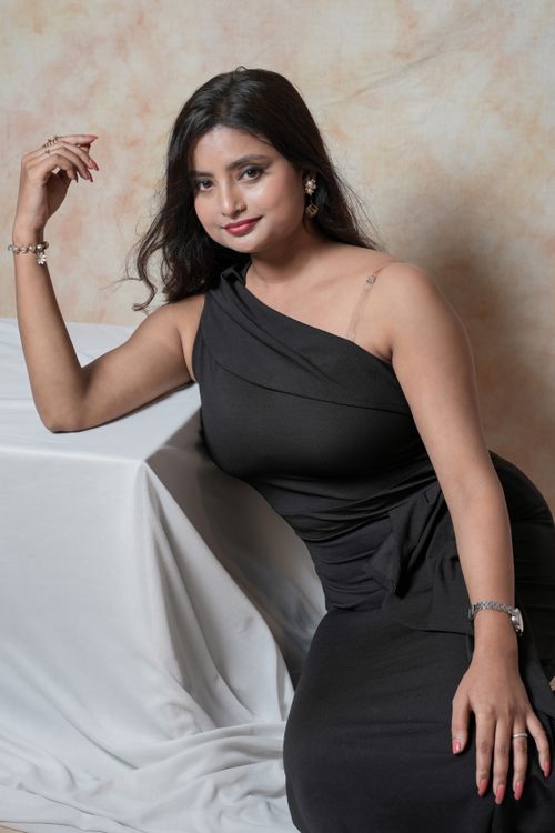 Free Stylish portrait of a woman in a black dress, elegantly posed against a textured background. Stock Photo