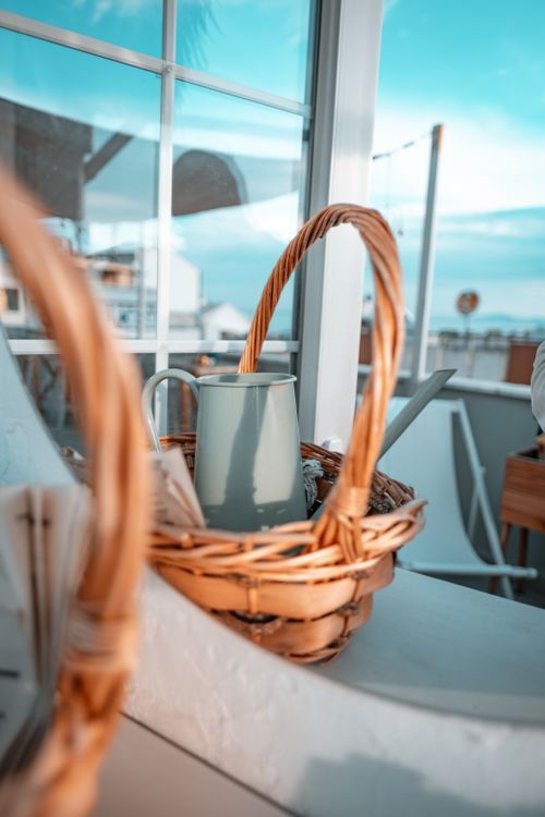 Free A wicker basket containing a jug and utensils on a bright terrace in Yalova, Türkiye. Stock Photo
