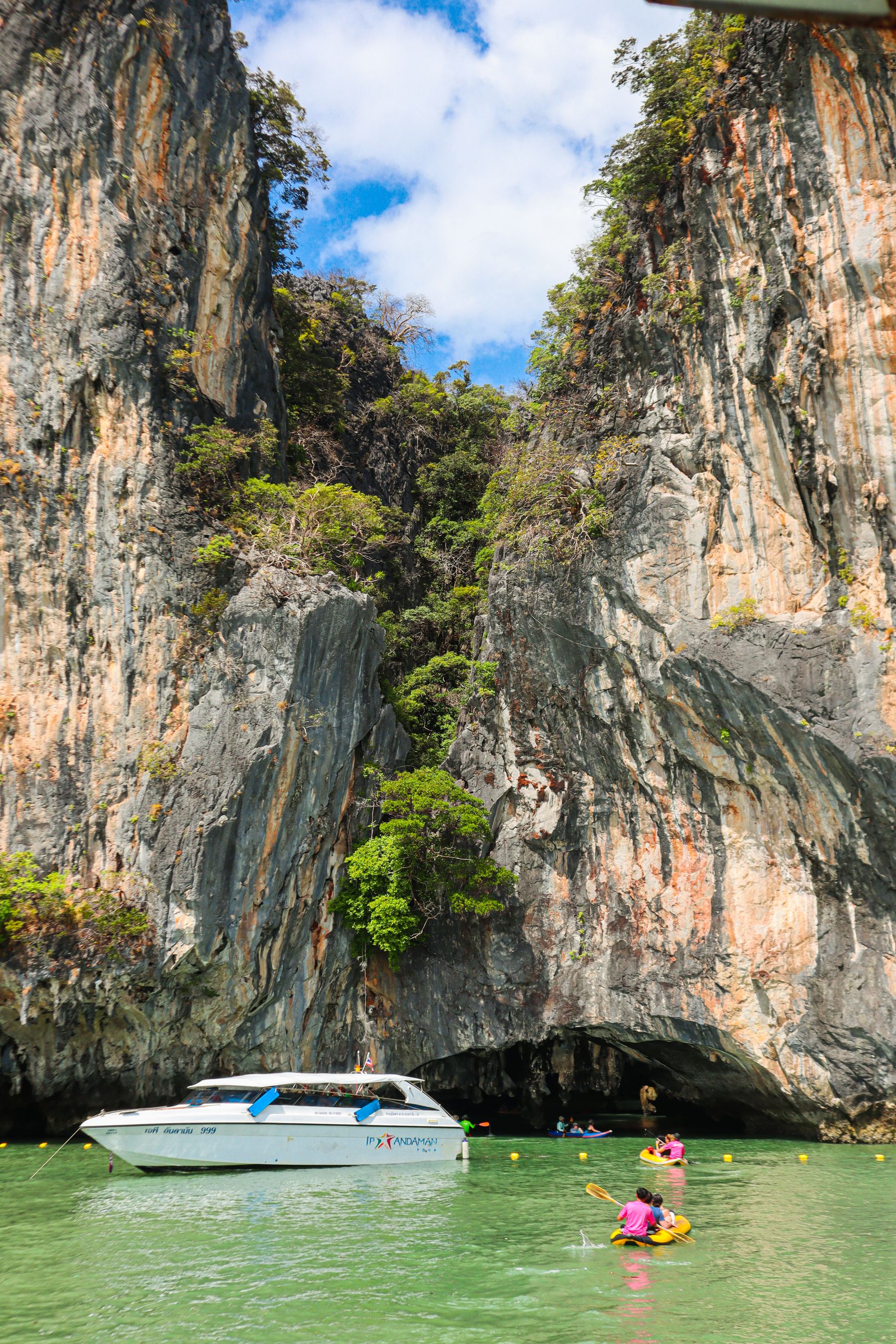 Travelers kayaking beneath limestone cliffs in Phang Nga Bay near Phuket