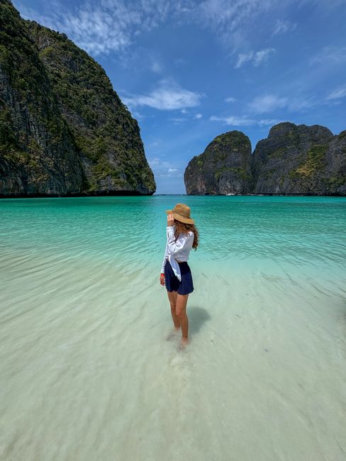 A woman enjoys the clear waters and stunning limestone cliffs of Maya Bay in Thailand.