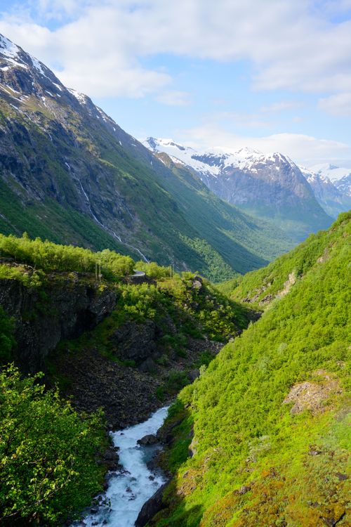 Free Breathtaking view of a lush valley with snow-tipped mountains in Norway. Stock Photo