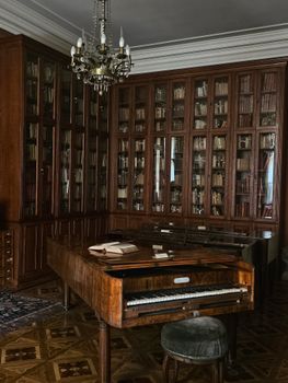 Vintage library interior in Kraków with wooden bookshelves and grand piano.