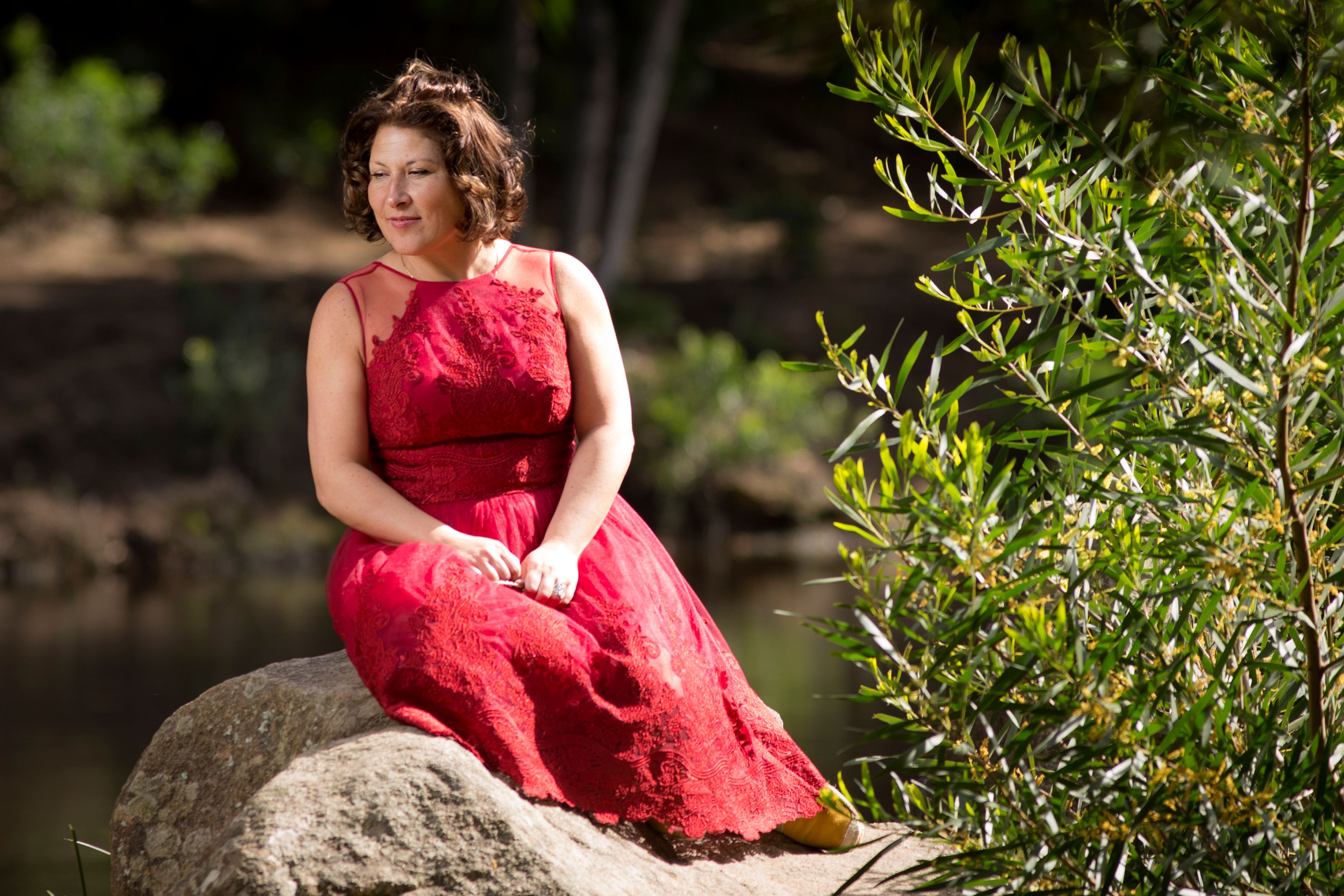 Woman in Red Dress Relaxing on Rock Outdoors · Free Stock Photo