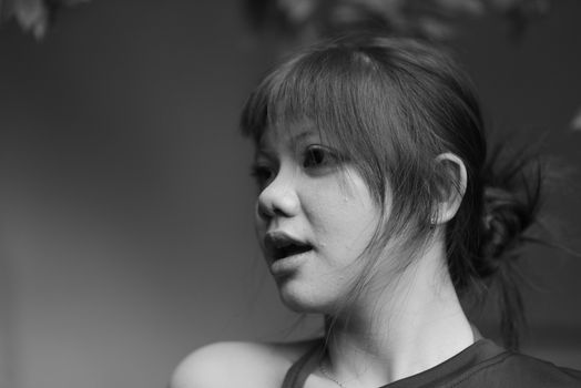 Artistic black and white portrait capturing a young woman's expression.