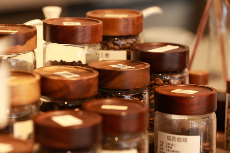 Coffee beans in an airtight container next to a bag of freshly roasted coffee