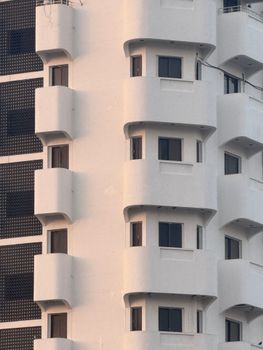 Close-up of a modern white residential building facade with geometric balconies.