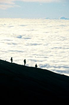 在云雾缭绕的背景下，登山者的身影在亚庇攀登一座被云雾笼罩的山峰。 - 相关推荐