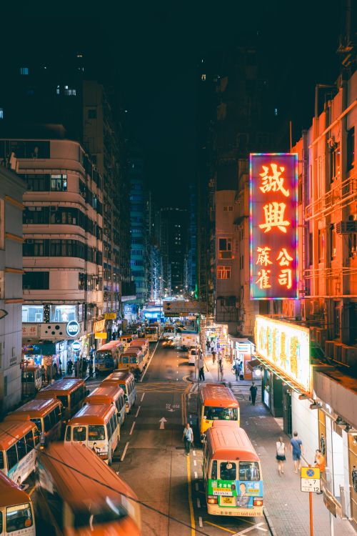 Free Bustling Hong Kong street with neon lights and lively nighttime atmosphere. Stock Photo