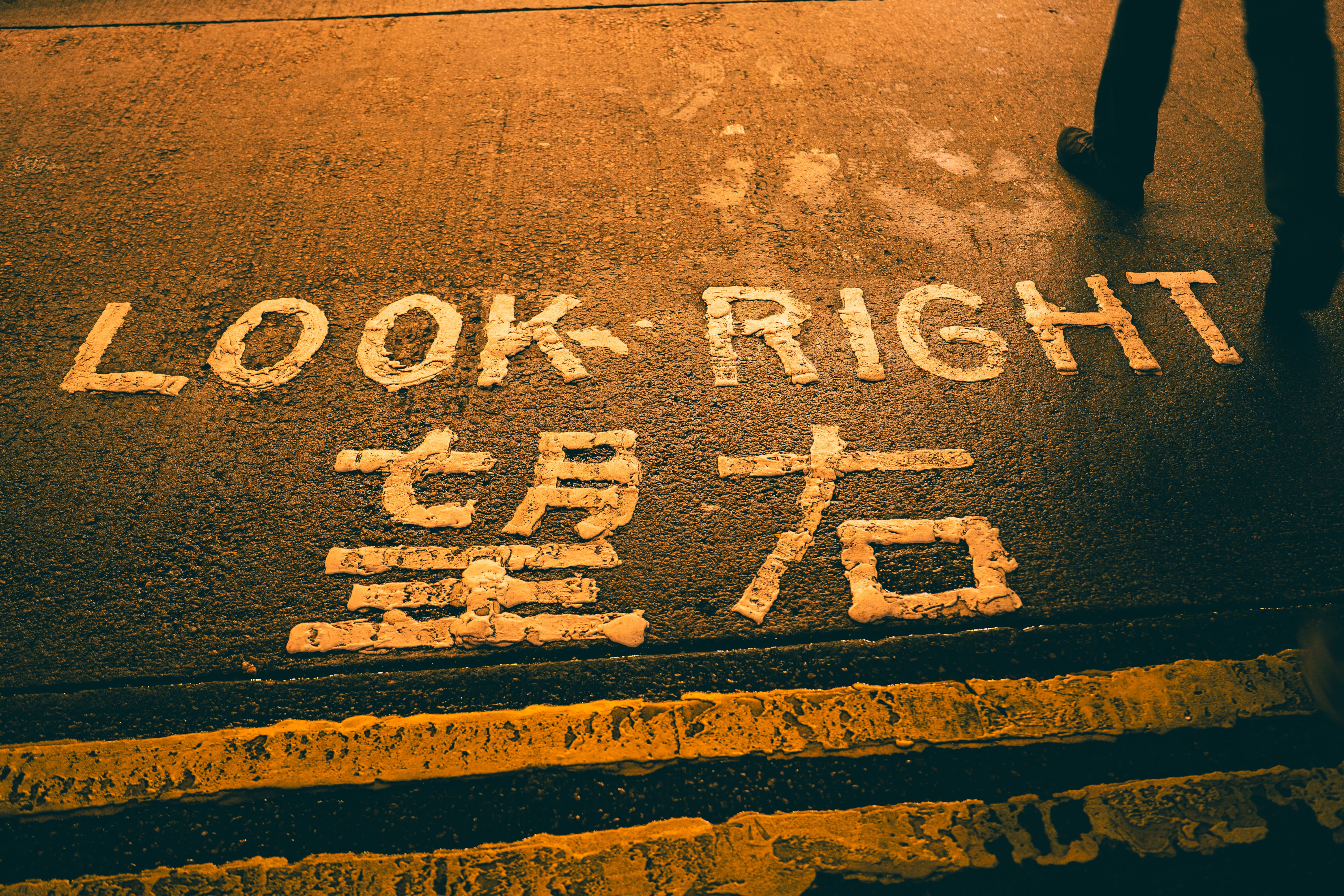 Crosswalk with 'Look Right' and Chinese text, evening street.