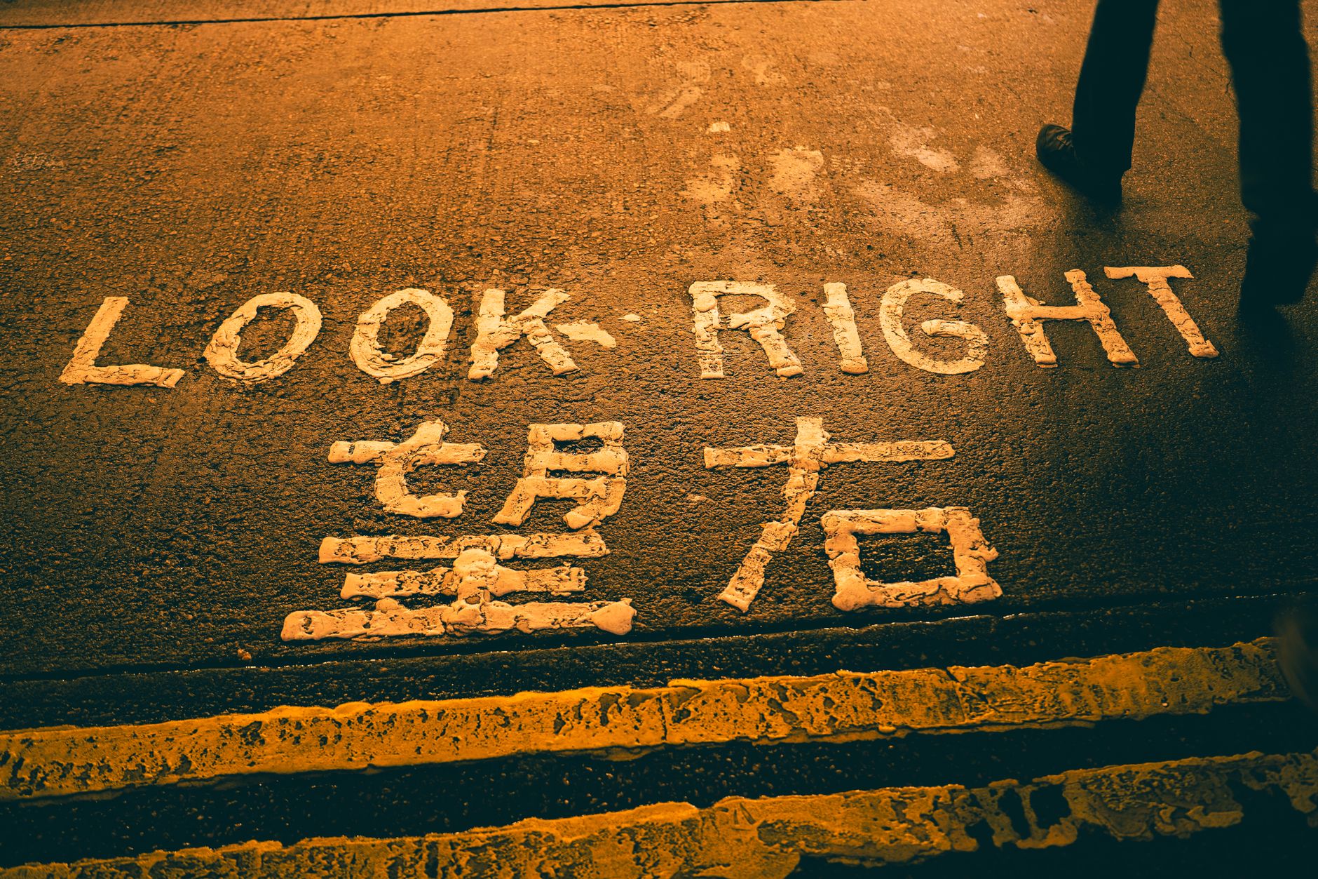 Crosswalk with 'Look Right' and Chinese text, evening street.