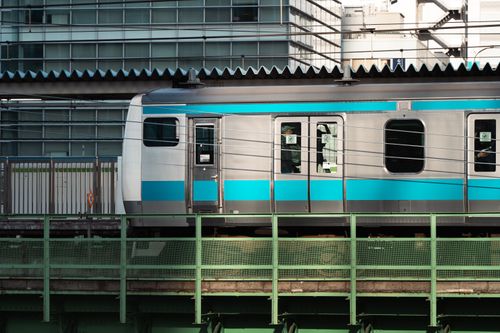 Free A vibrant train on elevated tracks through Tokyo, Japan, showcasing urban architecture. Stock Photo