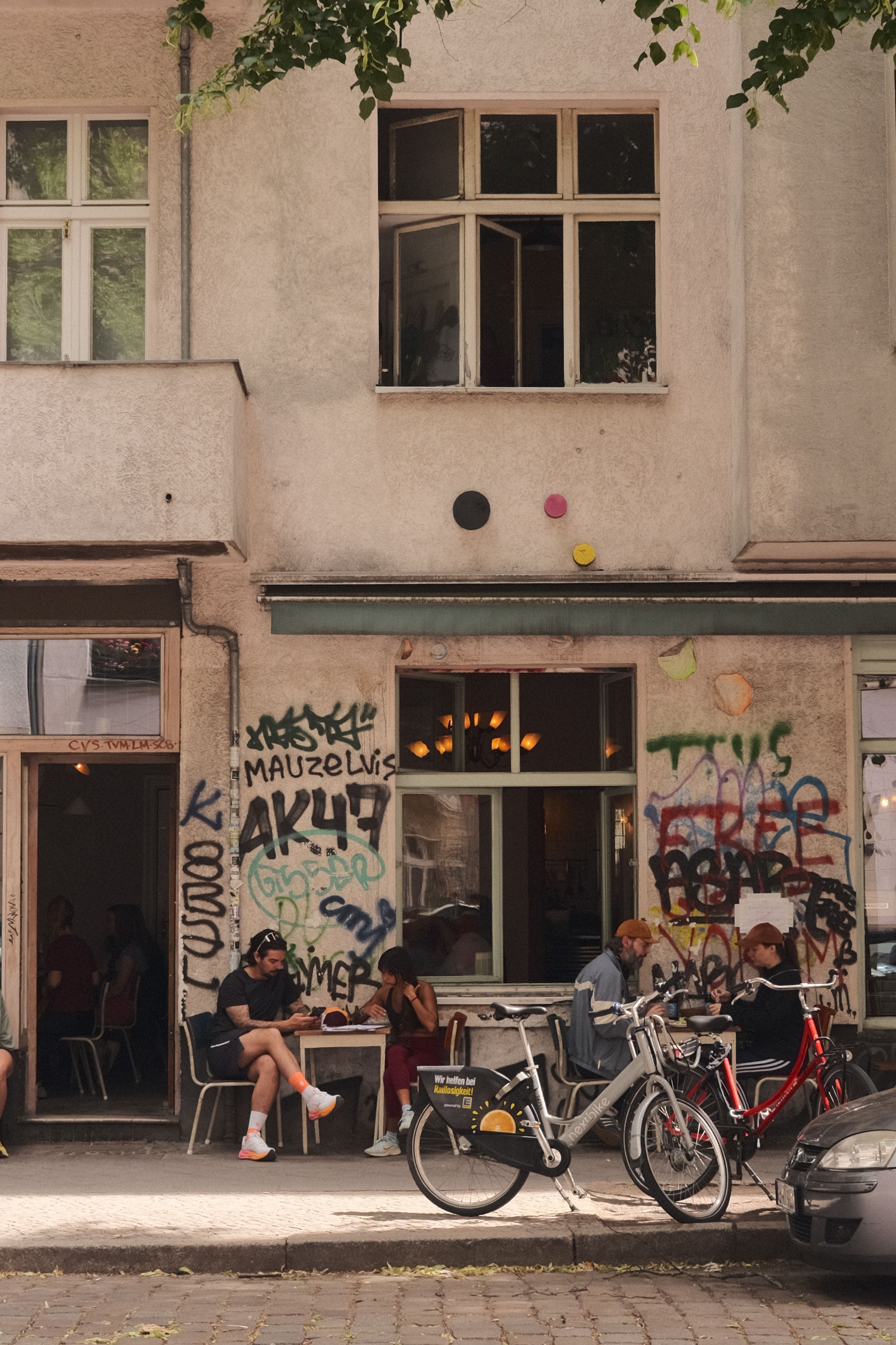 Street view of a Berlin café with graffiti and bicycles parked outside, capturing the city's vibrant urban life.