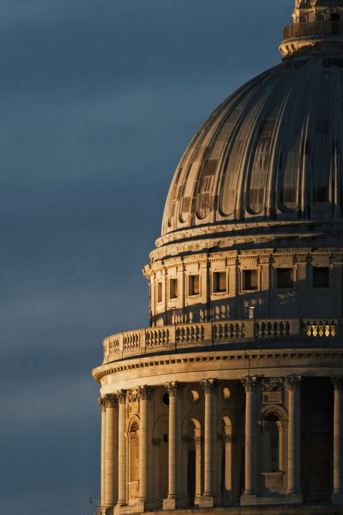 Free Close-up of a sunlit dome of a historic building under a dramatic sky, captured during sunset. Stock Photo