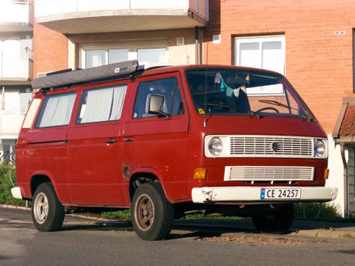 Free A vintage red Volkswagen camper van parked on a quiet street in Oslo, Norway, capturing classic automotive charm. Stock Photo