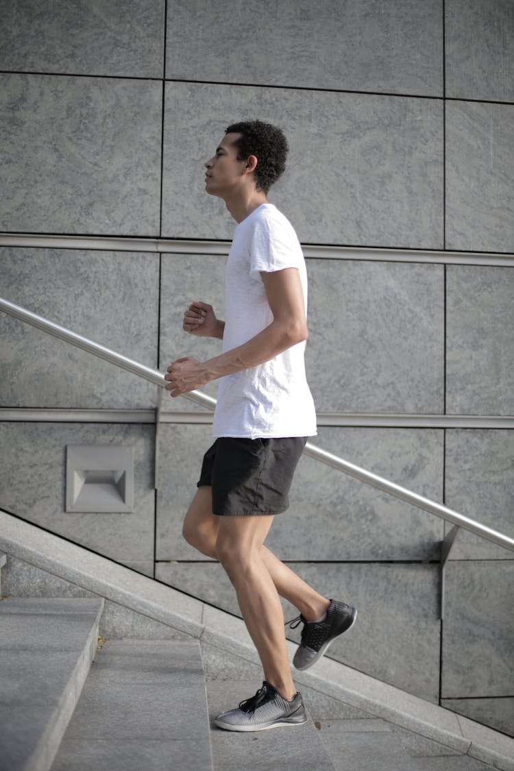 Muscular Determined Ethnic Male Athlete Is Running Up Stairs On Street