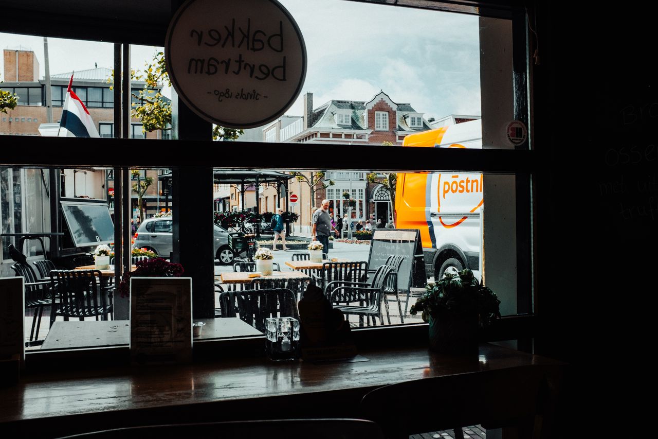 view from a cafe window featuring outdoor seating street scene and pos