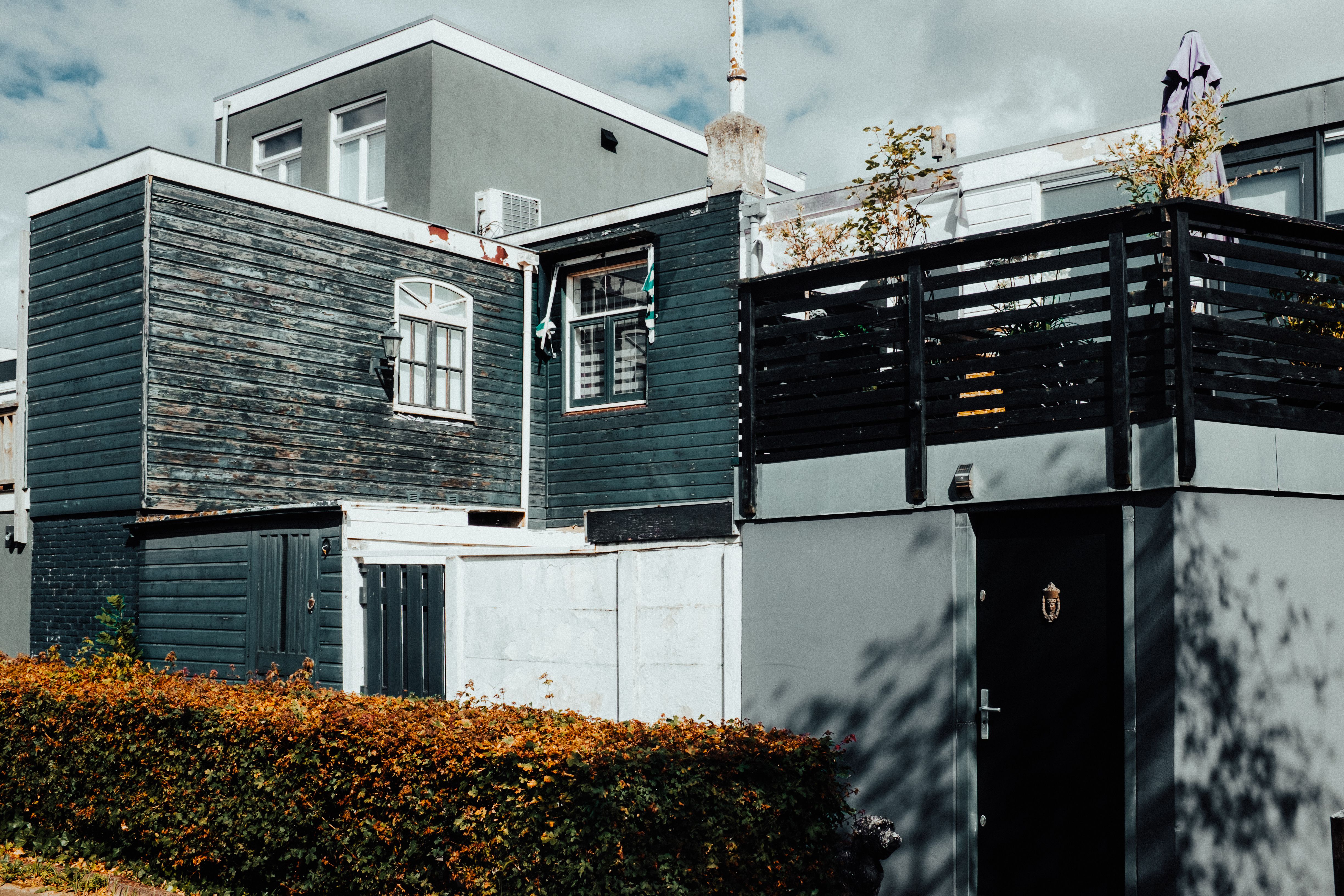 Modernes mehrstöckiges Gebäude umgeben von Herbstlaub – Architekturfotografie von Tasso Mitsarakis