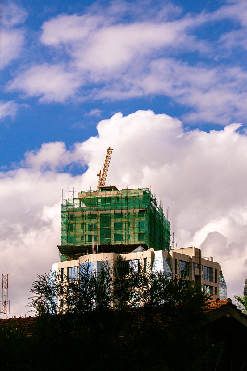 Skyscraper in Nairobi with crane on bright day under blue skies