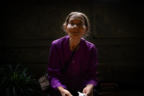 Free A serene portrait of an elderly woman in Hanoi, Vietnam, showcasing local attire and quiet dignity. Stock Photo