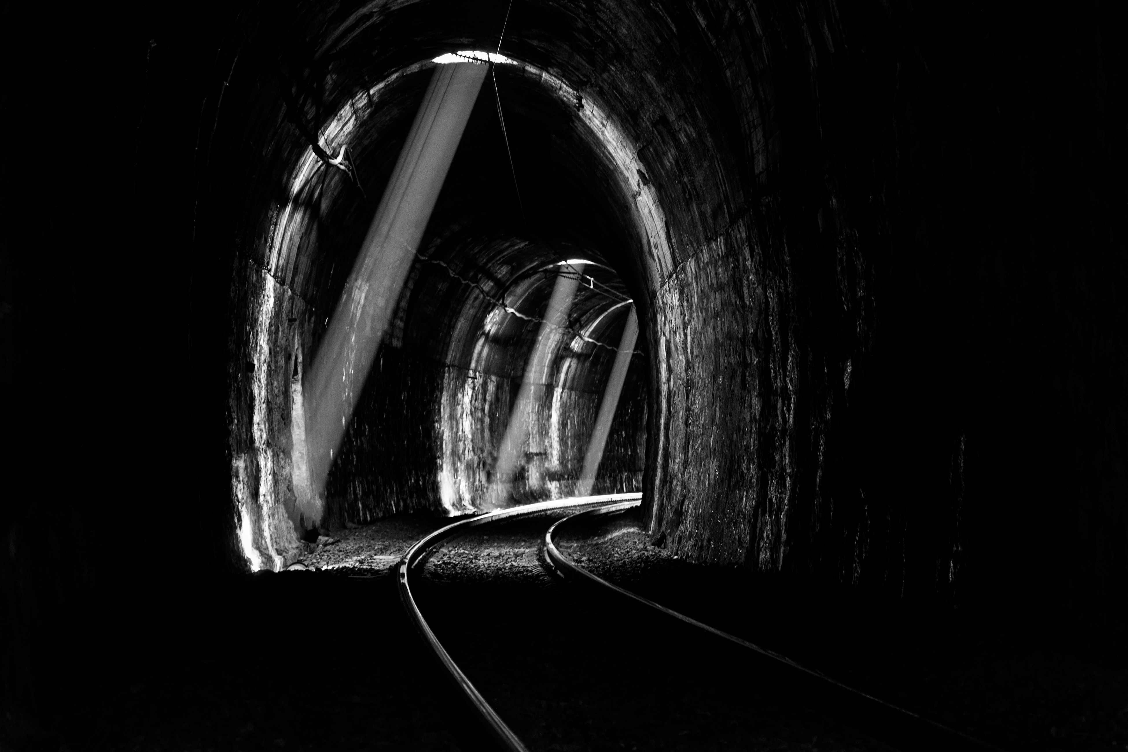 A railway tunnel piercing a dark mountainside