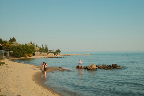 Free Peaceful beach scene with people enjoying the summer shore. Stock Photo
