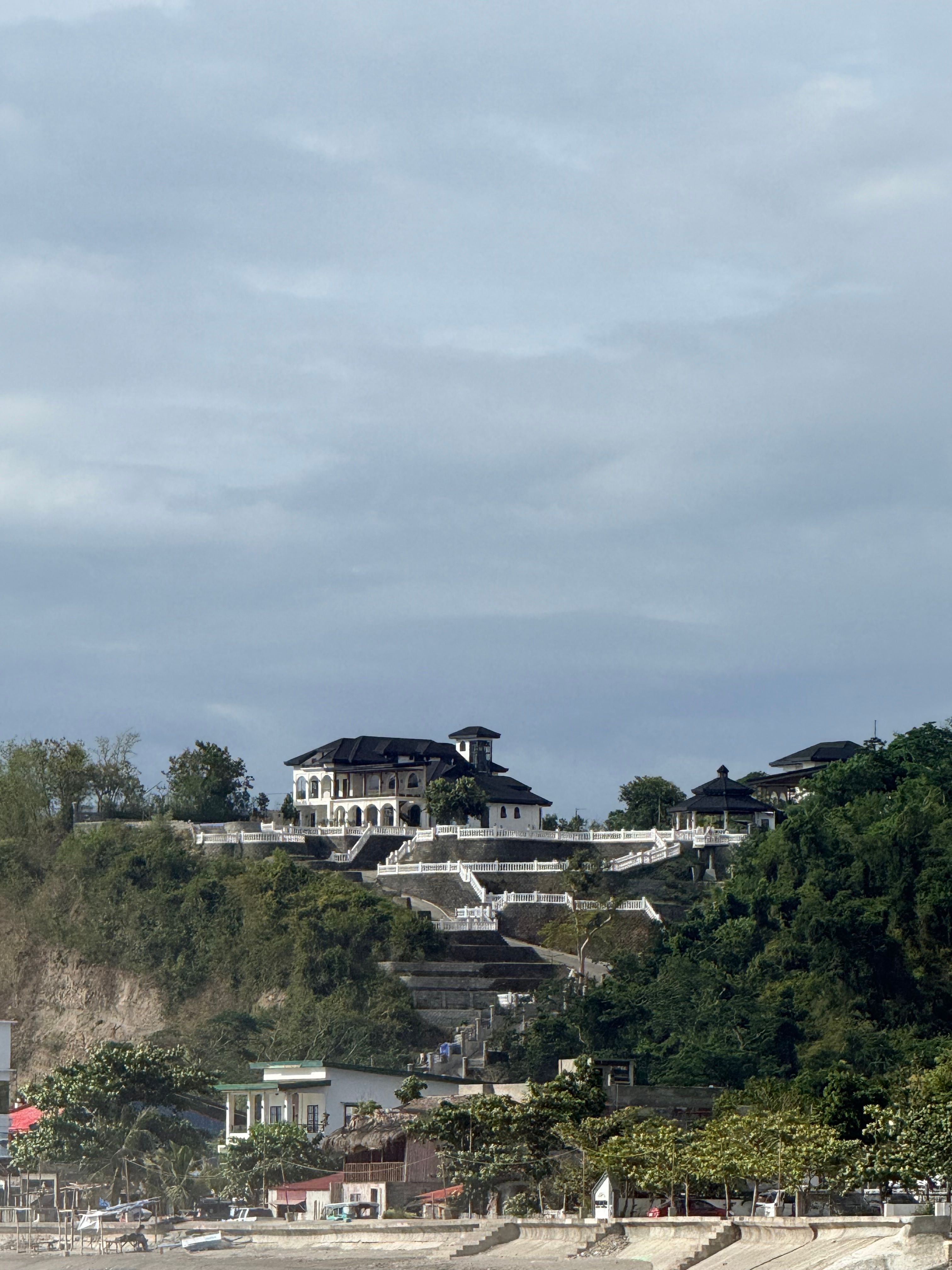 Elegant hillside estate with sweeping coastal views, capturing architectural beauty and nature.