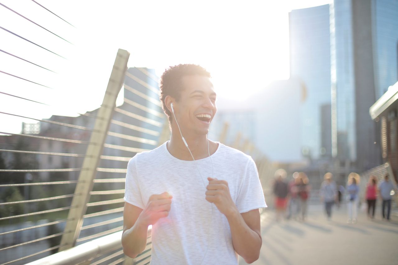 low angle of young african american man in earphones and white shirt l