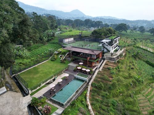 Free Aerial view of a luxury resort and pool set amidst the lush greenery of Jawa Tengah, Indonesia. Stock Photo
