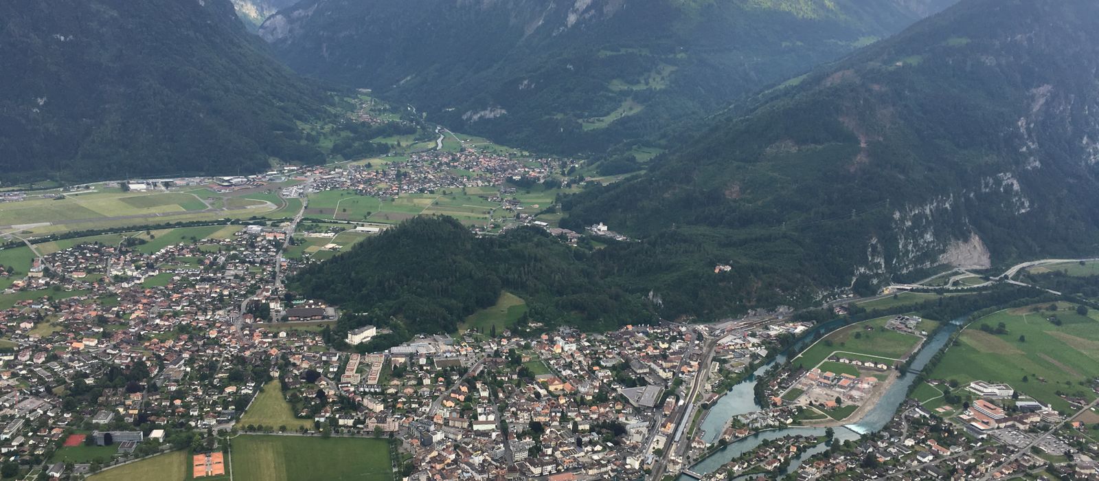 Stunning aerial view of Interlaken surrounded by the magnificent Swiss Alps under cloudy skies.