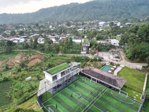 Free Aerial view showcasing a football field and surrounding village in Jawa Tengah, Indonesia. Stock Photo