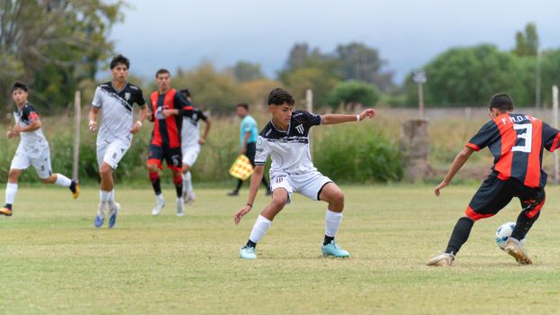 Dynamic youth soccer match with players in action outdoors on a grassy field.
