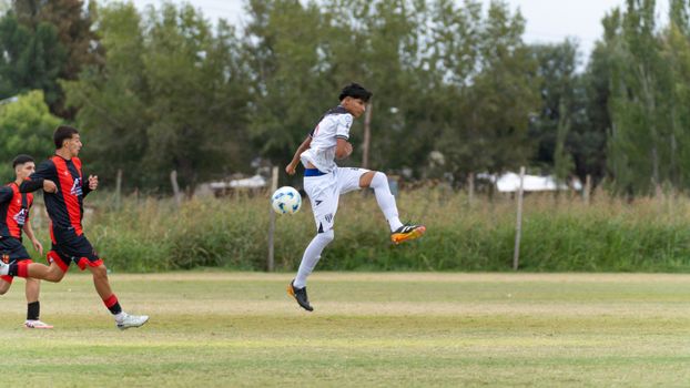 Teenage soccer players in action on an outdoor field, capturing a moment of intense competition.