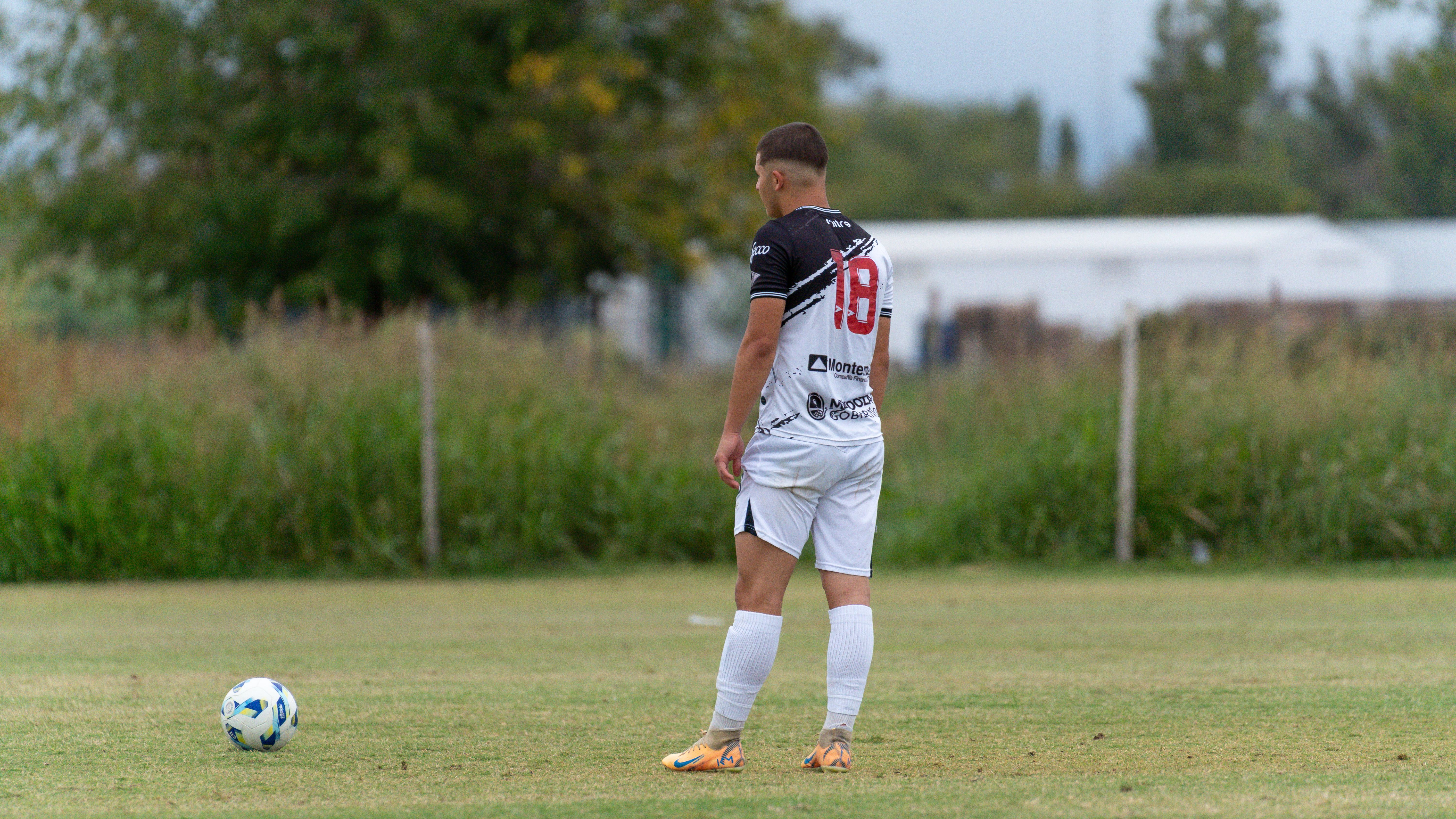 Soccer player stands on the field during a game, ready to play.