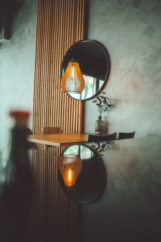 Stylish modern interior with a warm glowing lamp reflection, featuring minimalist decor and textures.