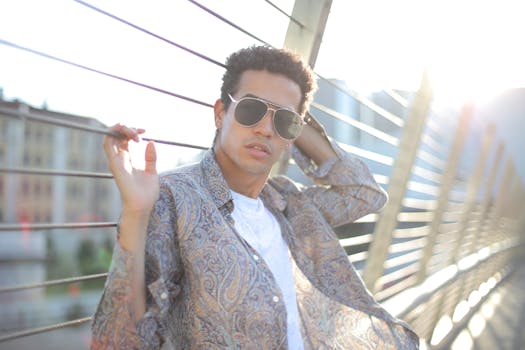 时髦的男人在城市的桥梁上摆姿势，拥抱阳光与时尚