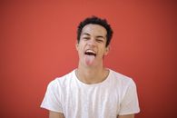Man in White Crew Neck T-shirt Sticking his Tongue out
