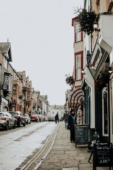 在阴暗的日子里，狭窄城市街道上的建筑物和汽车外部