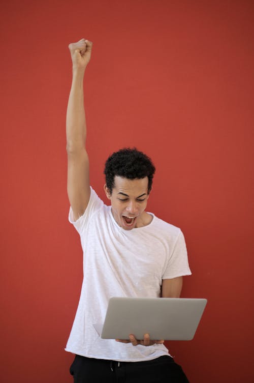 Free Man in White Crew Neck T-shirt Raising His Right Hand Stock Photo