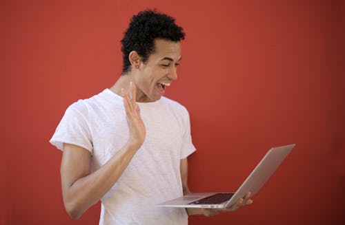 Gratis Hombre Alegre Usando Laptop Para Videollamada Foto de stock