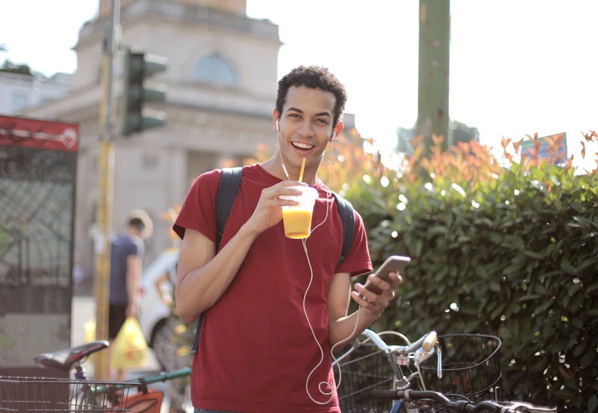 Happy young man using smartphone on street