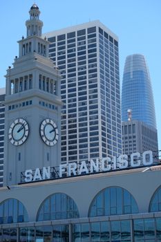 View of the iconic San Francisco Ferry Building with the city skyline on a clear day.