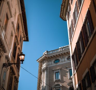 Charming view of Roman architecture against a clear blue sky, showcasing classic building details.