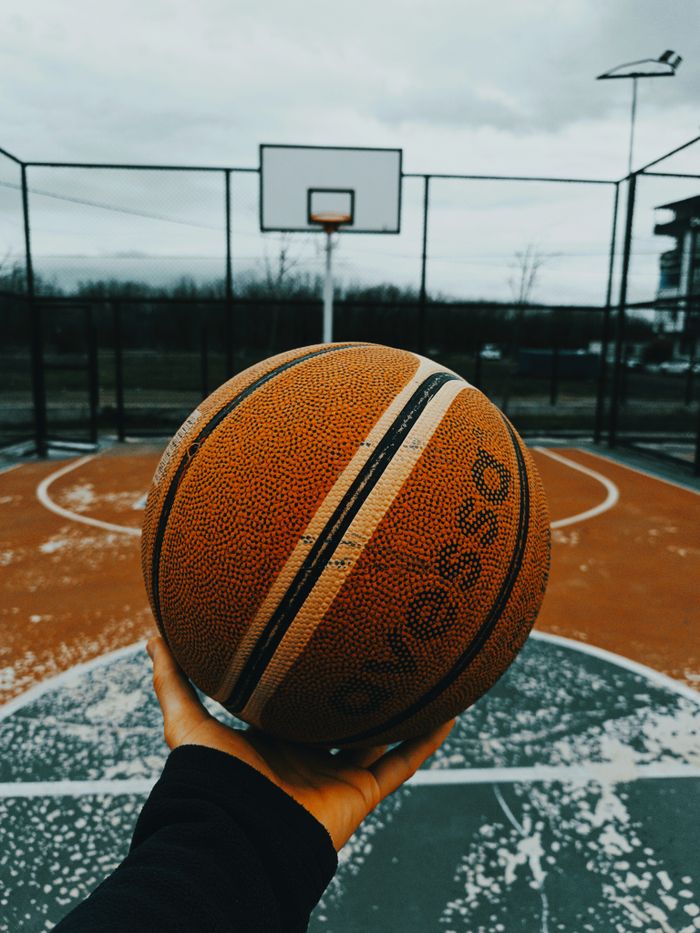 Wide-angle view of an illuminated basketball court in an empty arena