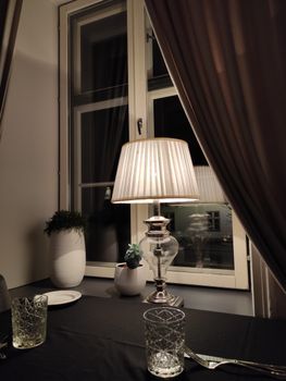 A cozy and elegant dining setup at night with warm lighting and a view outside.