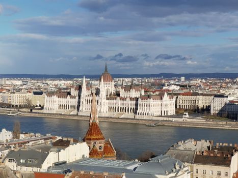 Stunning aerial shot of Budapest's iconic Parliament Building by the Danube under blue skies.