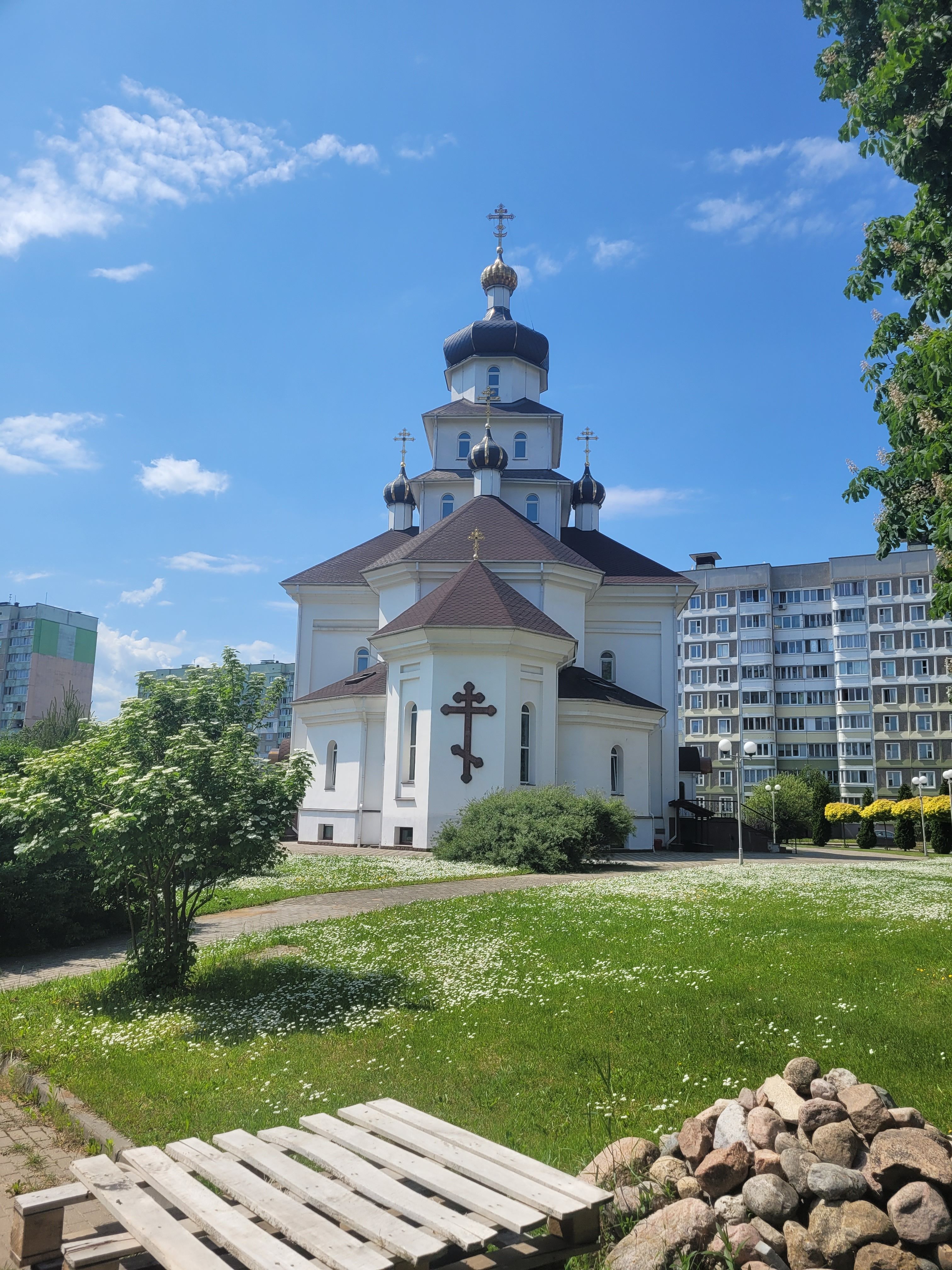 Capture of an elegant Orthodox church with distinct architecture and vibrant greenery.
