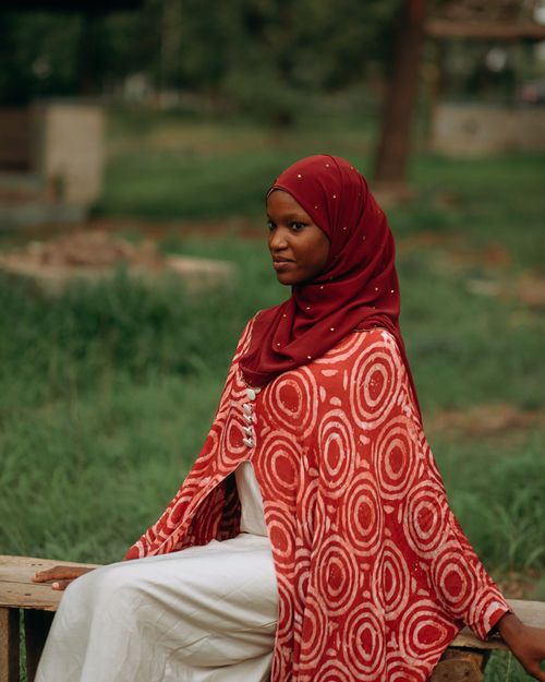 Free A portrait of a woman in traditional clothing, captured outdoors in a serene setting. Stock Photo